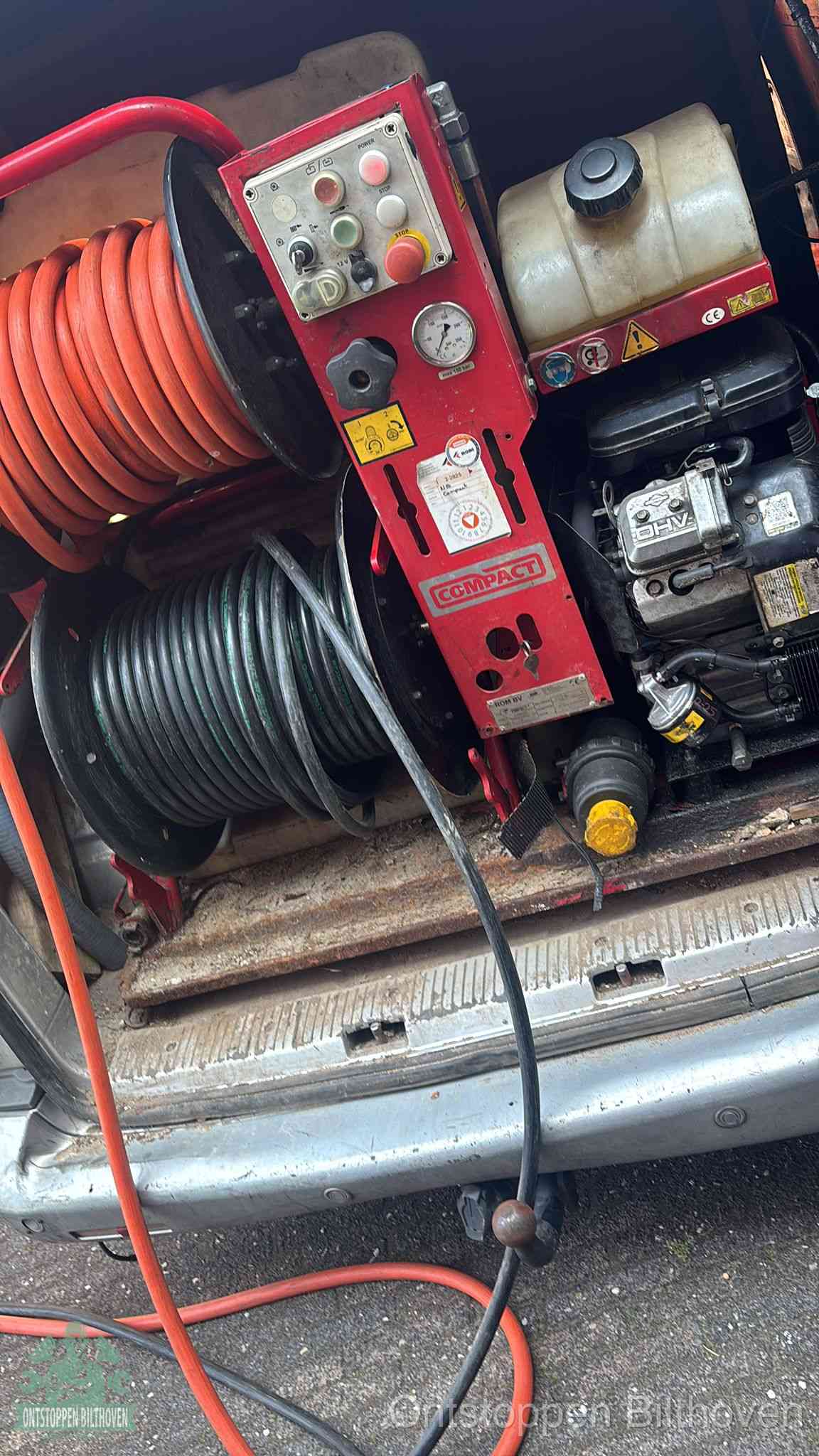 Een rood hogedruk-rioolreinigingstoestel in de laadbak van de bedrijfsbus, apparatuur voor een hardnekkige afvoerverstopping in Bilthoven