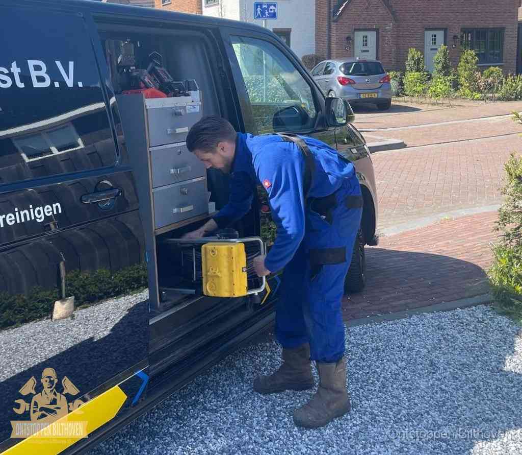 Een monteur pakt apparatuur uit de bedrijfsbus voor service aan huis, het moment om een professional in te schakelen voor een verstopte wc in Bilthoven