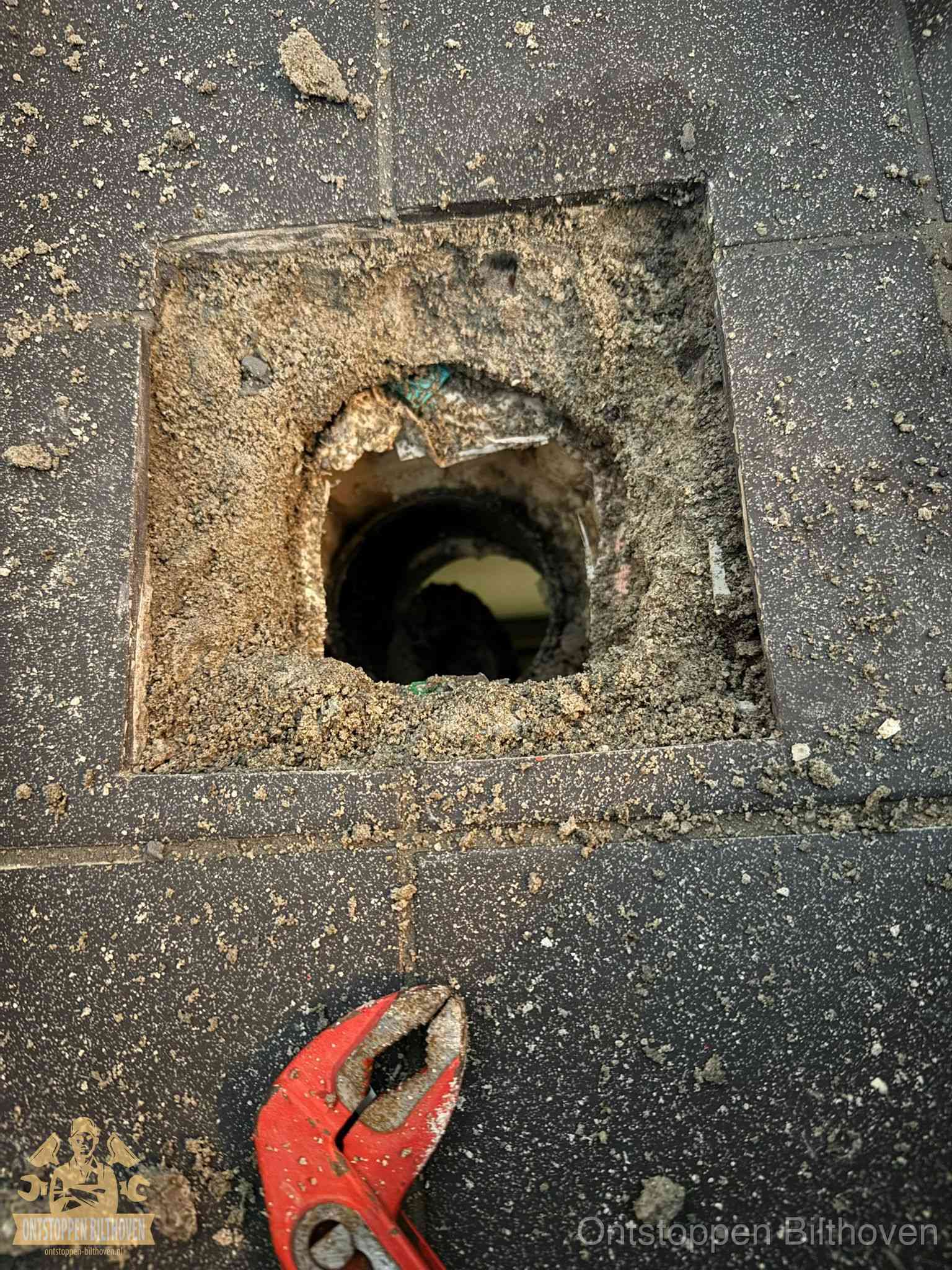 Geopend rioolputje op de erfgrens dat laat zien wie eigenaar is van de riolering in Bilthoven