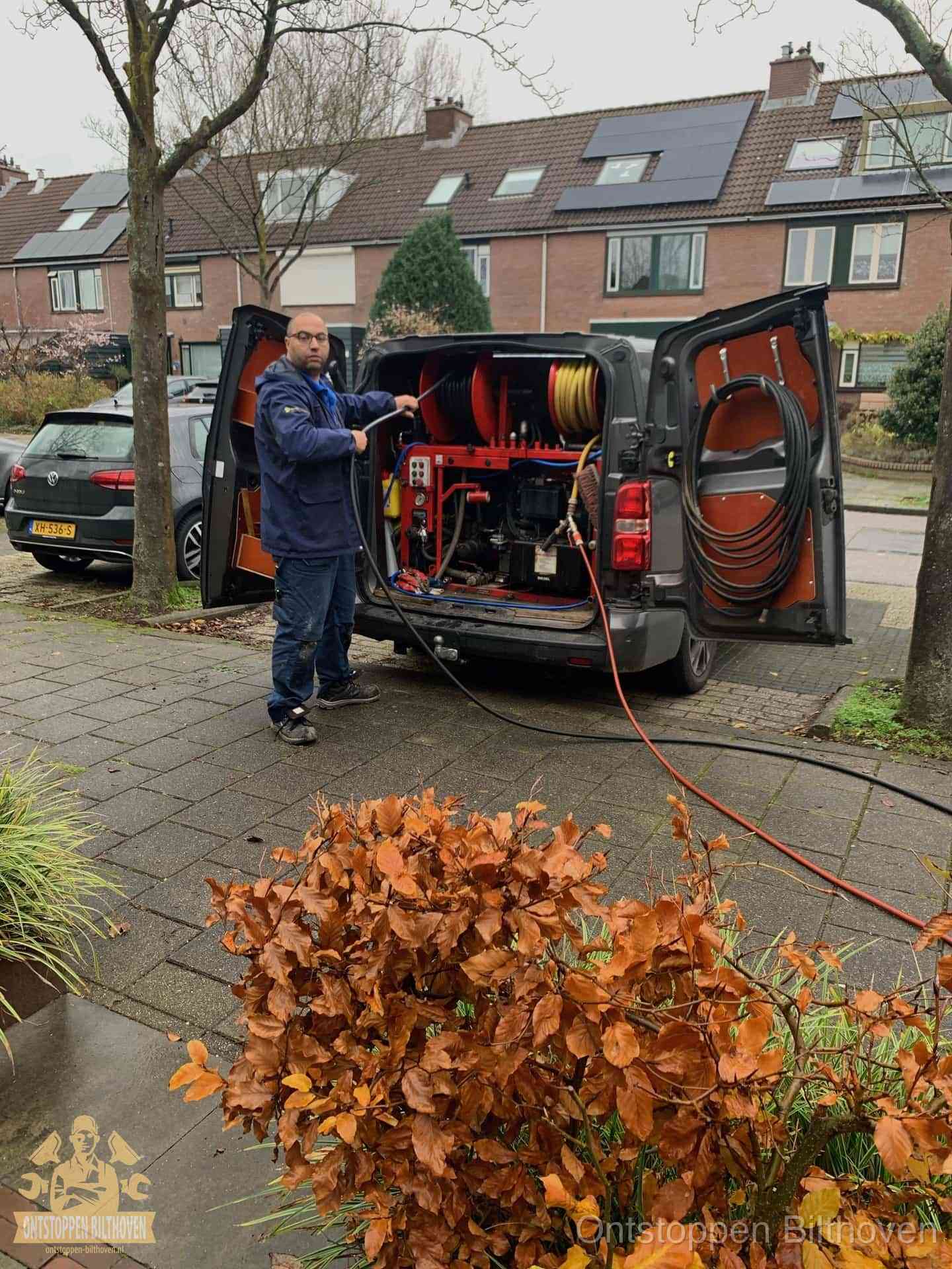 Monteur met rioolreinigingsbus levert rioolservice in de wijk in Bilthoven