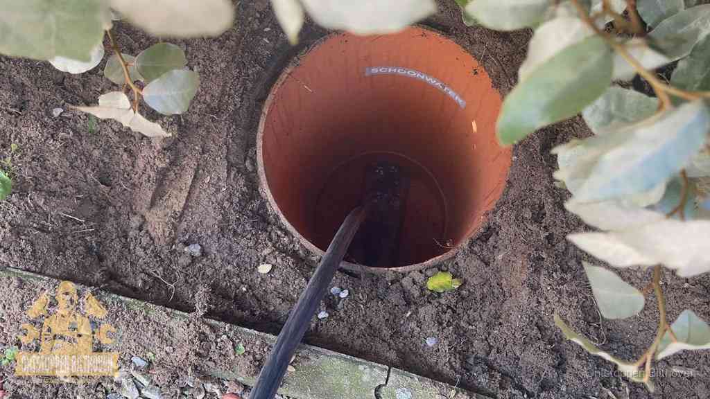 Open inspectieput in de tuin waar een veer rioolvliegjes en stankoverlast aanpakt in Bilthoven