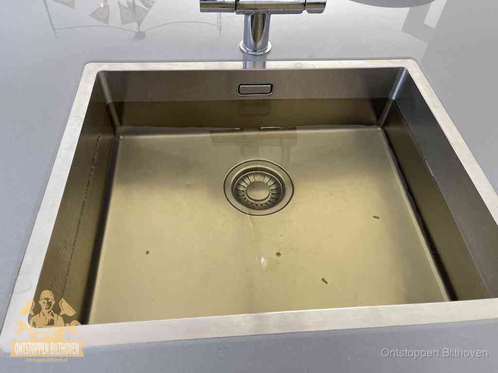 Stilstaand water in een rvs spoelbak dat niet wegloopt, een duidelijk signaal van een gootsteenverstopping in Bilthoven
